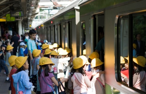 Children board a train at Tokyo station