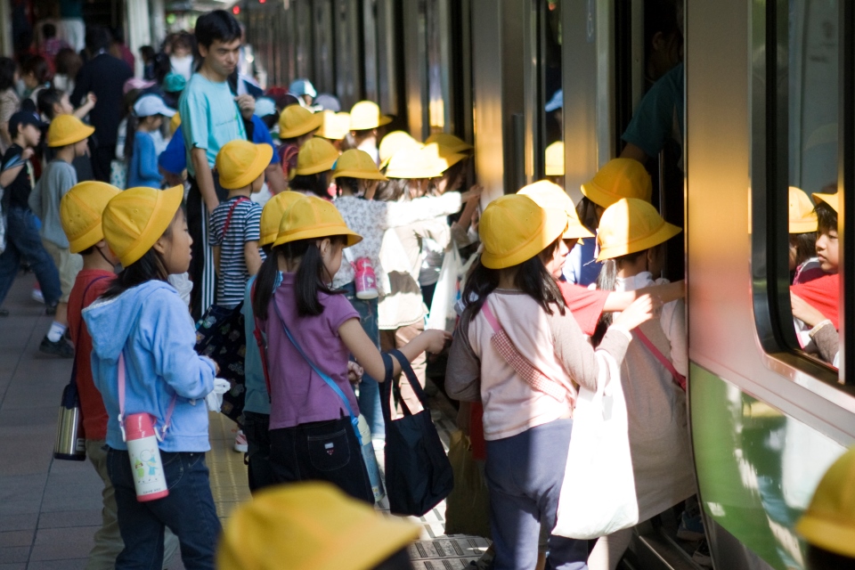 Japanese schoolchildren board train at station